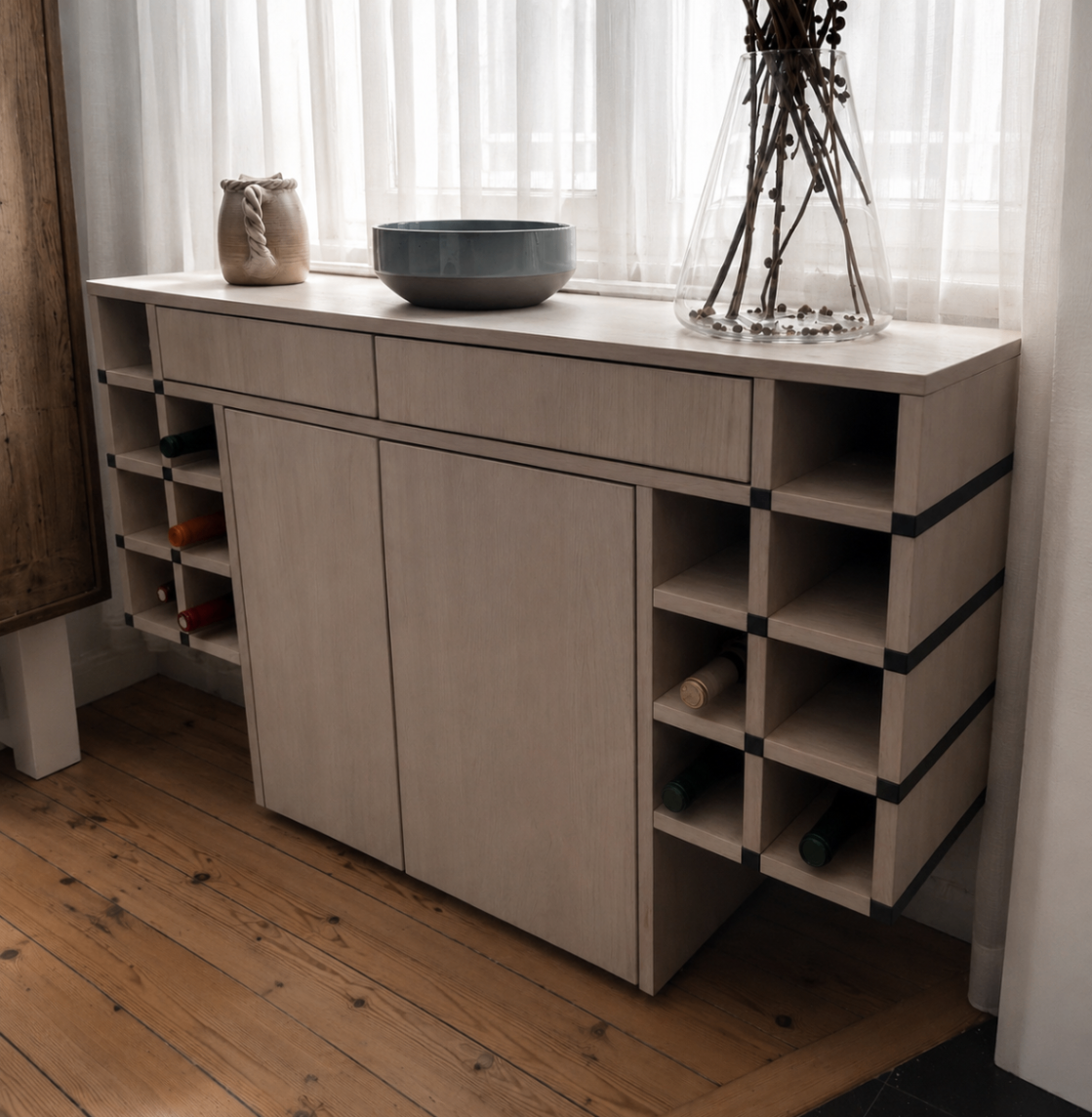 Light oak sideboard with wine storage in front of sheer curtains